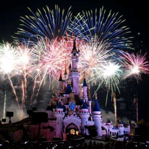 bright expoding fireworks in red white and blue over fairy tale castle