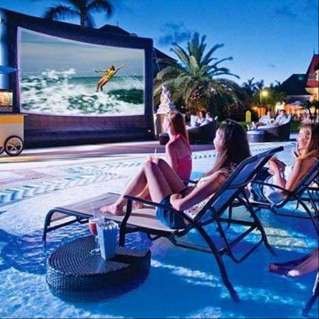 people in swimsuits watch an outdoor sports film